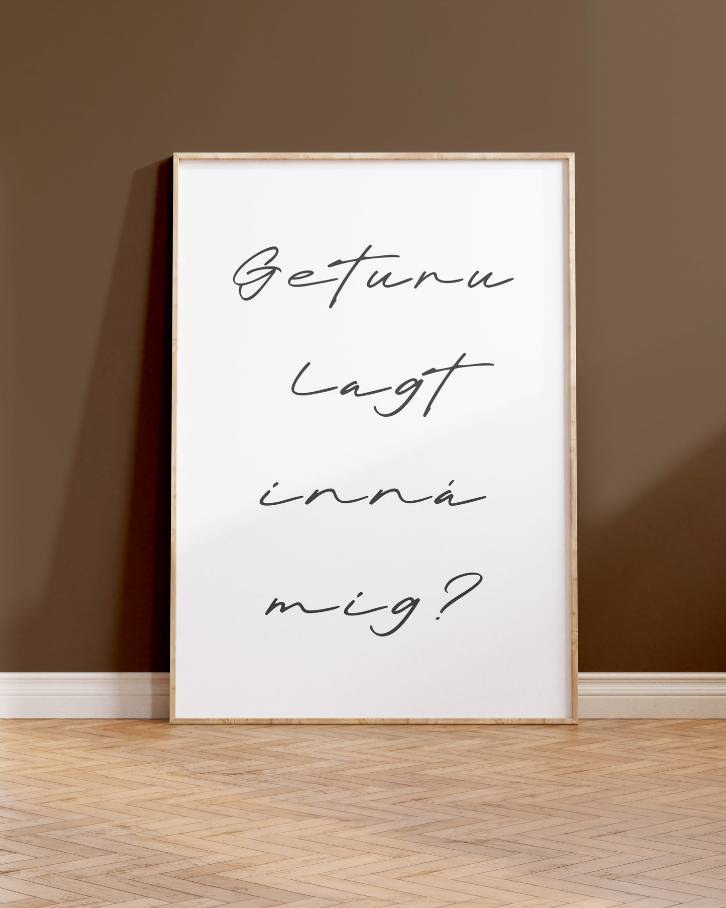 Innramað plakat upp við brúnan vegg