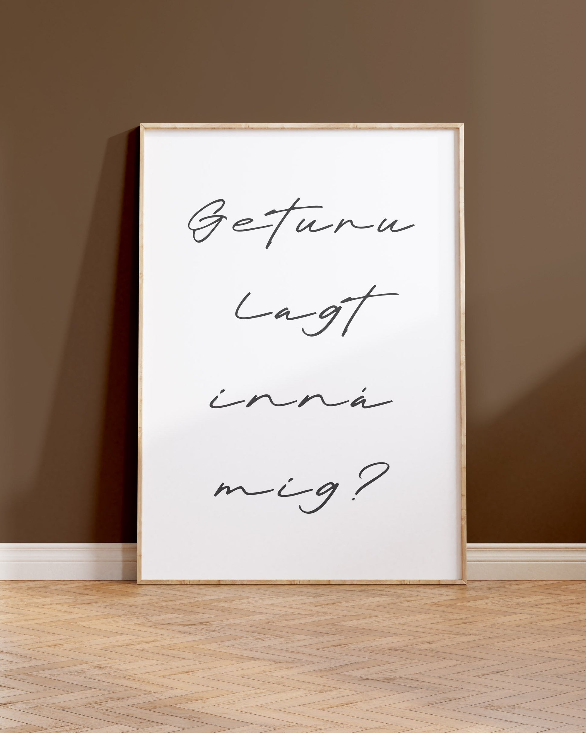 Innramað plakat upp við brúnan vegg