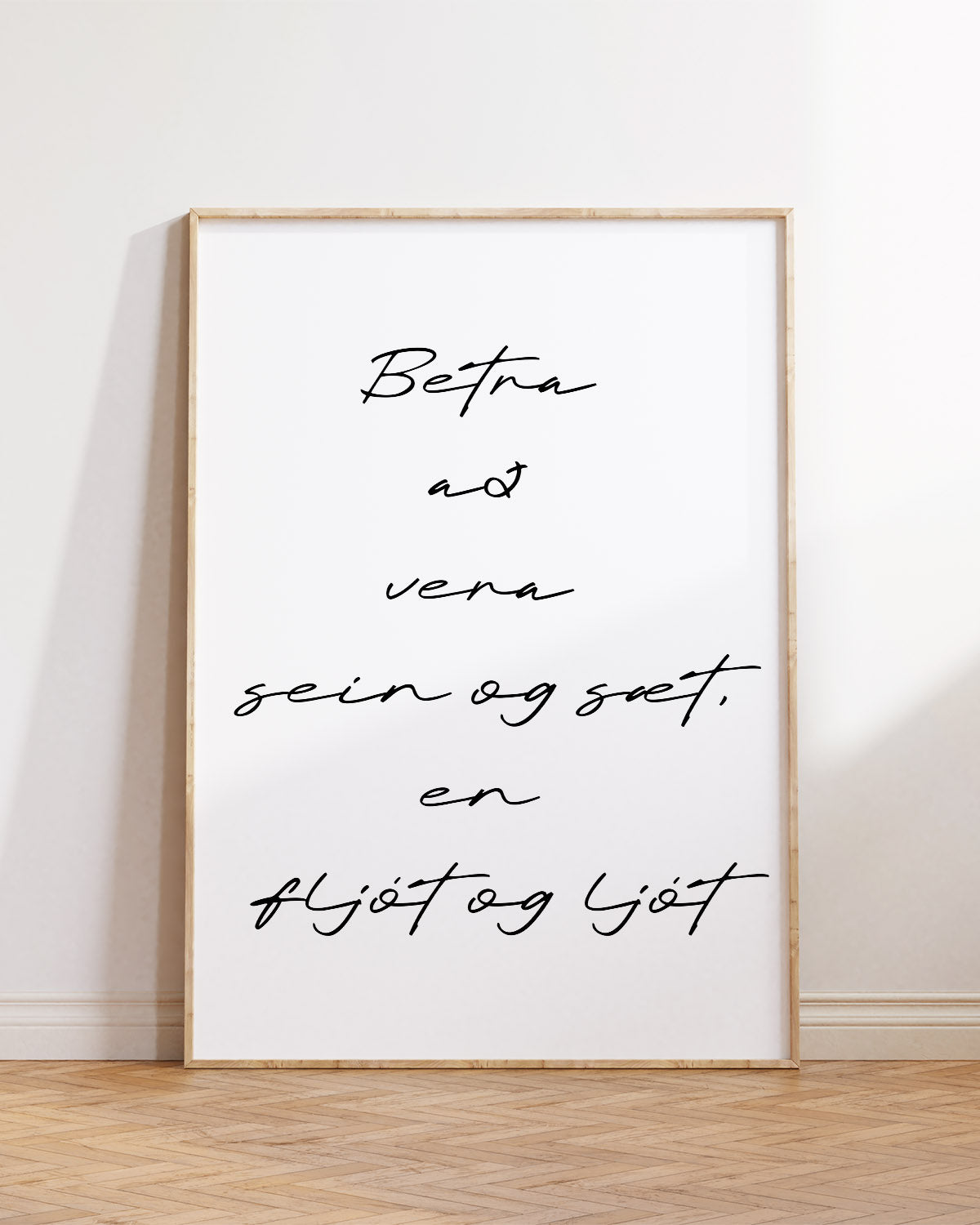 Veggspjald í ramma upp við hvítan vegg með textanum: Betra að vera sein og sæt, en fljót og ljót