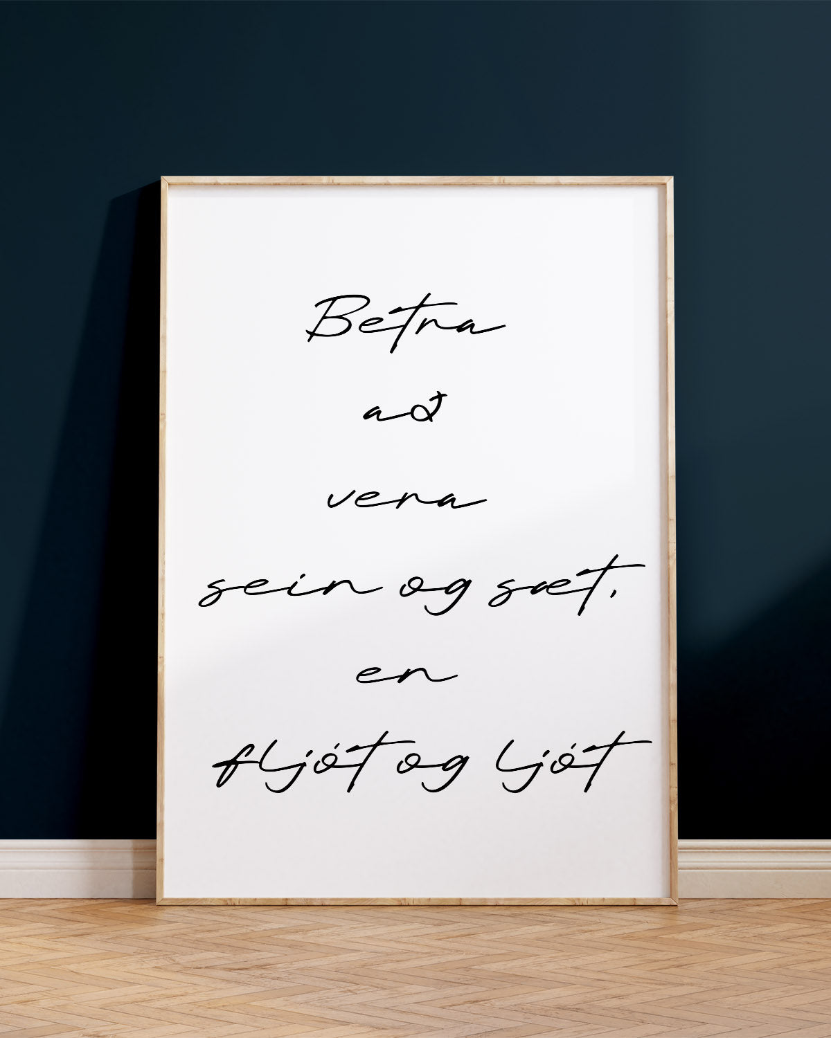 Veggspjald í ramma upp við bláan vegg með textanum: Betra að vera sein og sæt, en fljót og ljót