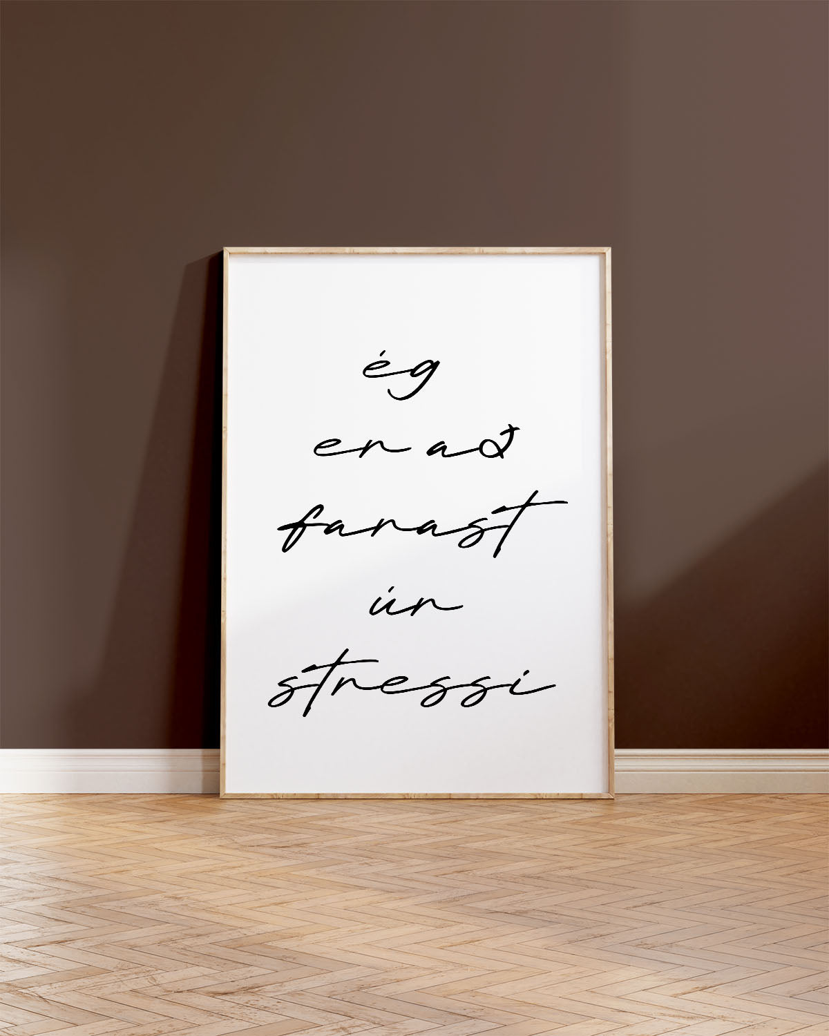 Veggspjald í ramma upp við brúnan vegg með textanum: ég er að farast úr stressi