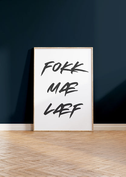 Veggspjald í ramma upp við dökkbláan vegg. Á veggspjaldinu stendur: Fokk Mæ Læf